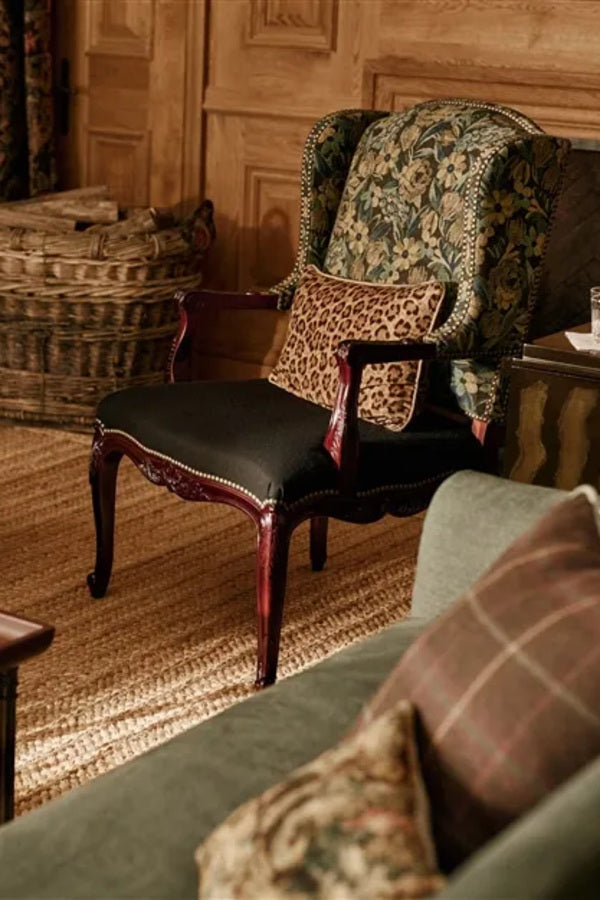 Ralph Lauren Saddlebrook floral fabric on an upholstered armchair in an elegant wood-paneled country living room